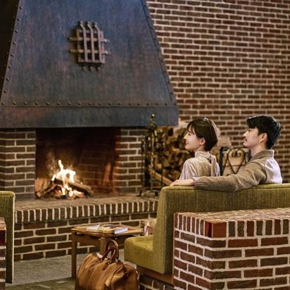 暖炉の前で寄り添う夫婦