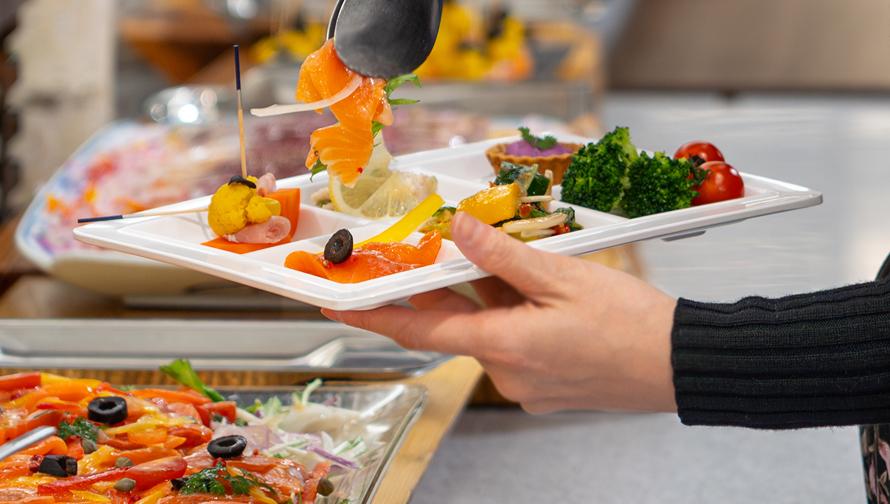 ブッフェにて料理を盛っている