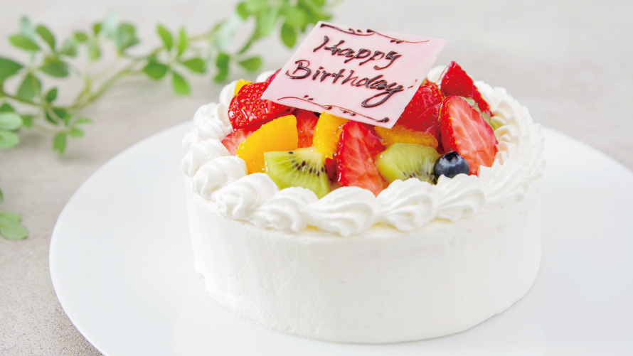 イチゴやオレンジ・キウイなどのカットフルーツが乗ったデコレーションケーキ