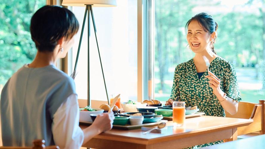 明るいレストランで朝食を楽しむ女性