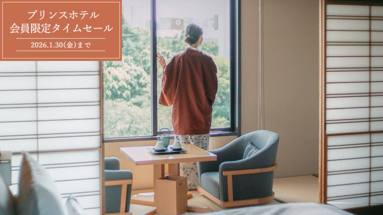 高輪 花香路客室で、窓辺から風景を眺める浴衣姿の女性客。