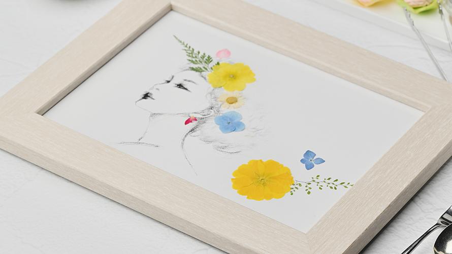 イラストの上にお花を重ねた“押し花アート”は額縁へ。