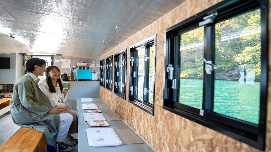 エメラルドグリーンに輝く朝の湖を眺めながらクルージング