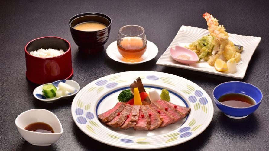ステーキと天ぷらを中心とした会席料理の写真です。ご飯や汁物、小鉢が添えられており、見た目にも美しい品々が並んでいます。