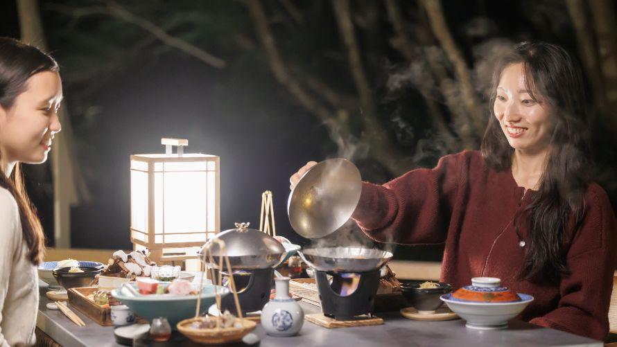 月見台で女性二人が懐石料理を楽しむ。