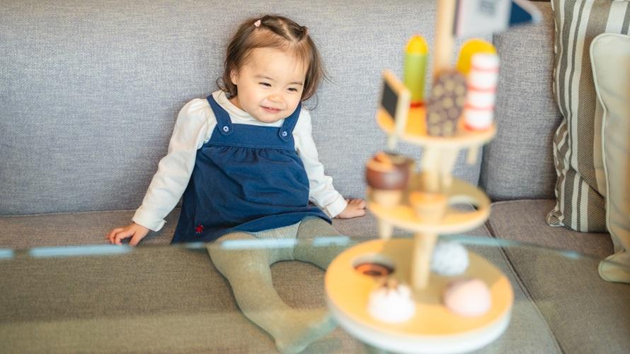 ソファに座り、にこにこの赤ちゃん。