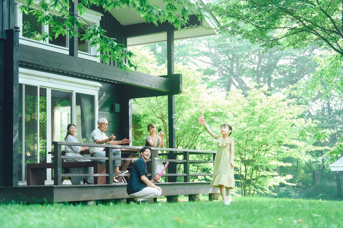 ヴィラで過ごす三世代家族 — 軽井沢の緑豊かなテラスでくつろぐ家族の様子