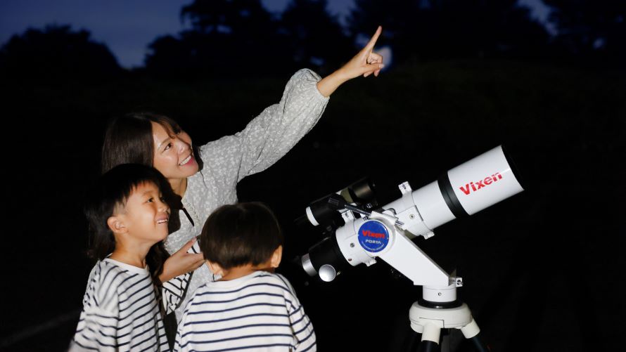旅館の外で星空を眺める親子