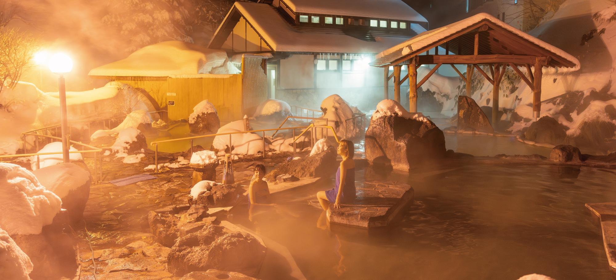 冬の石庭露天風呂に佇む女性2人の様子