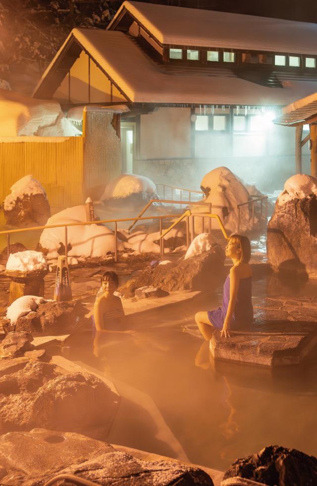 冬の石庭露天風呂に佇む女性2人の様子