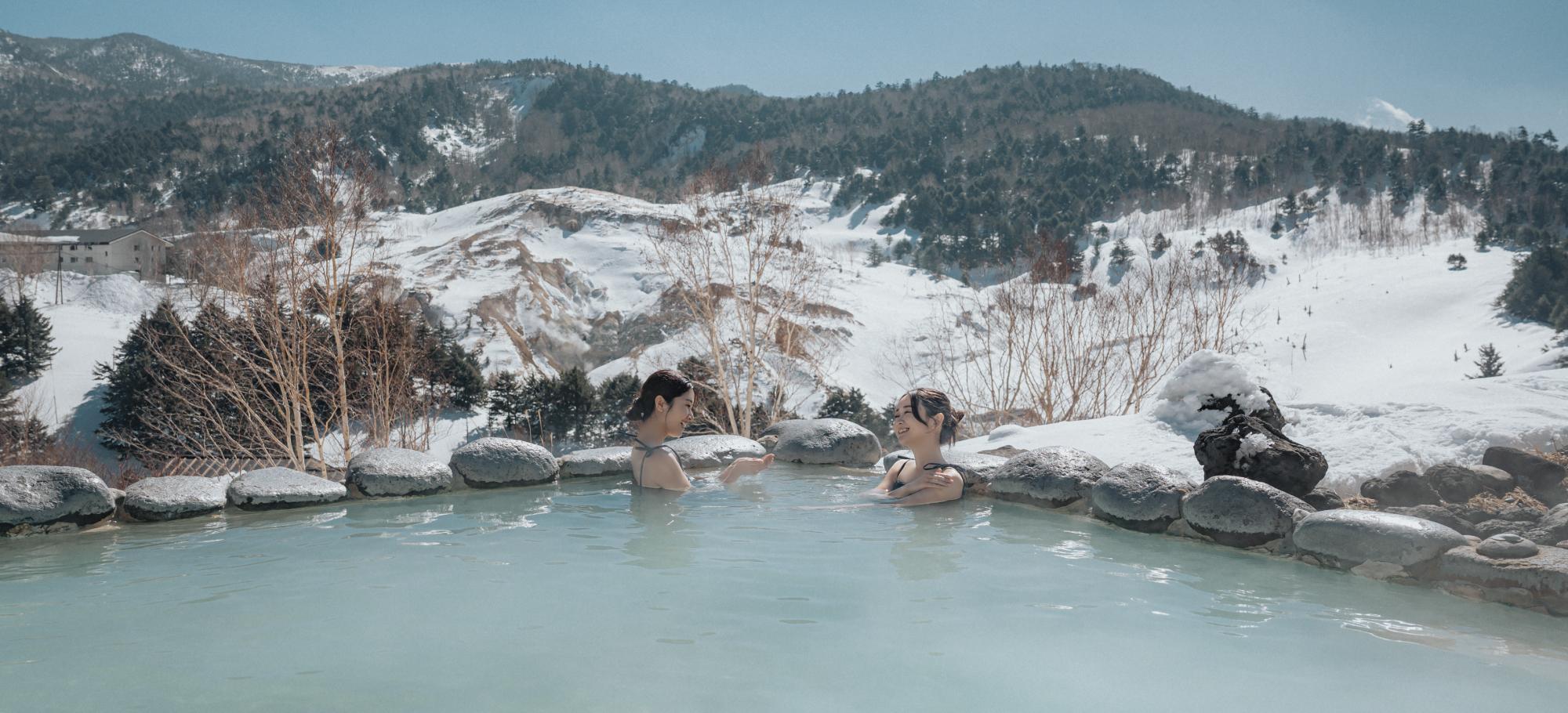 雪見露天風呂を楽しむ女性2人の画像