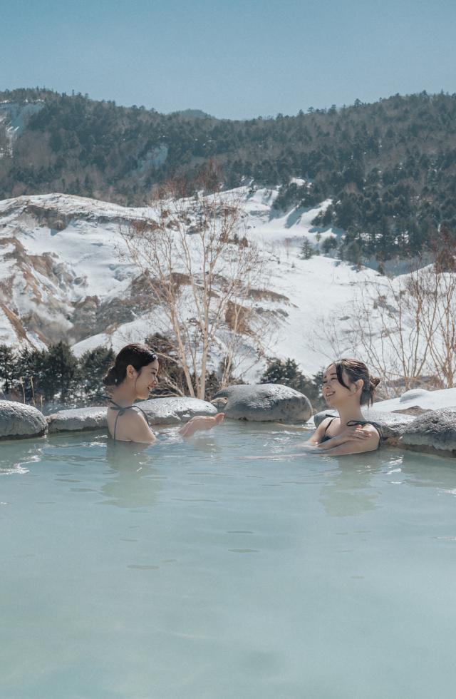 雪見露天風呂を楽しむ女性2人の画像