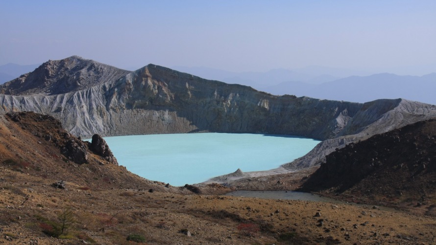 エメラルドグリーンに輝く湯釜の画像