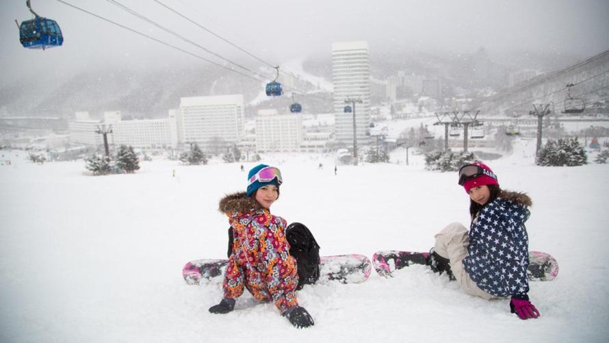 女性２名がスノーボードをしている