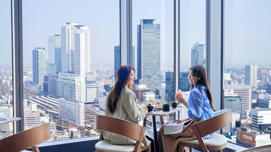 2人の女性が窓側の席で食事を楽しんでいる様子