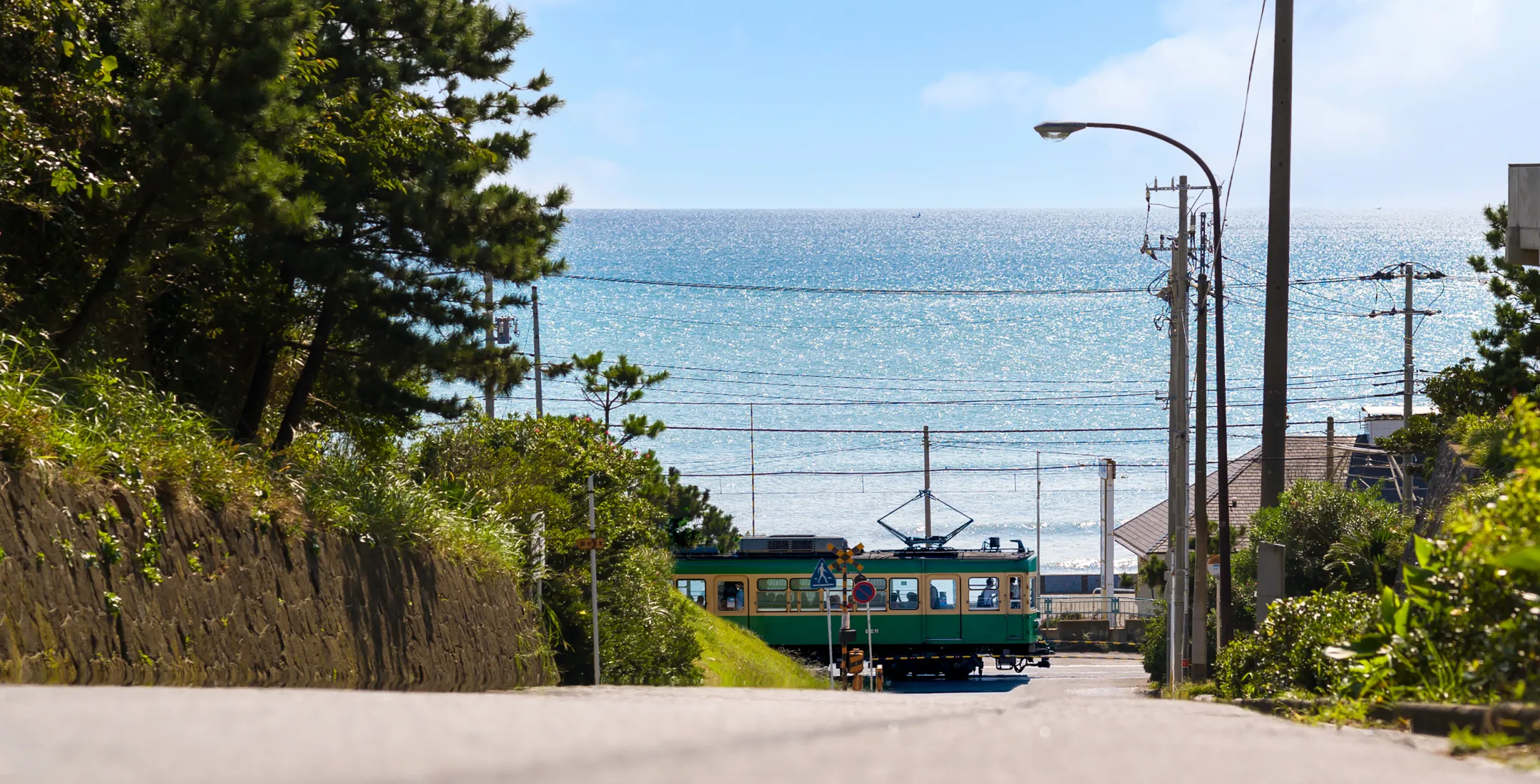 AdobeStockより「海辺を走る江ノ電」