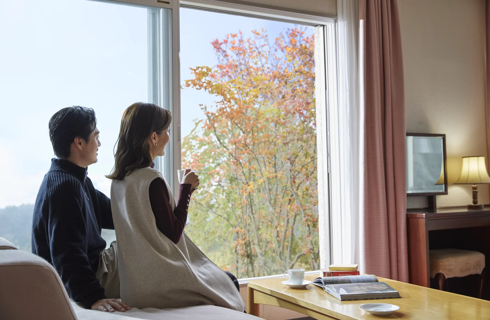 嬬恋プリンスホテル公式Webサイトより「窓辺から秋の木々を眺める客室」