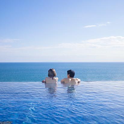 プールで海を眺めるカップル