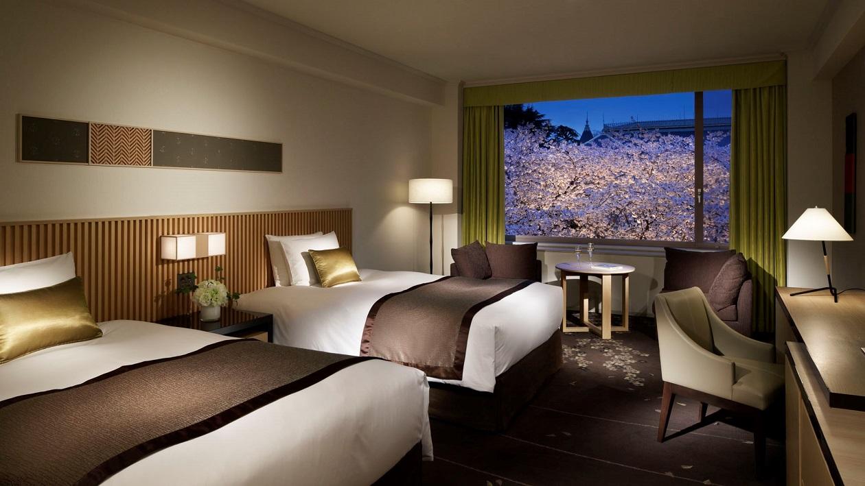 窓一面に桜景色を愉しめるホテルの客室。