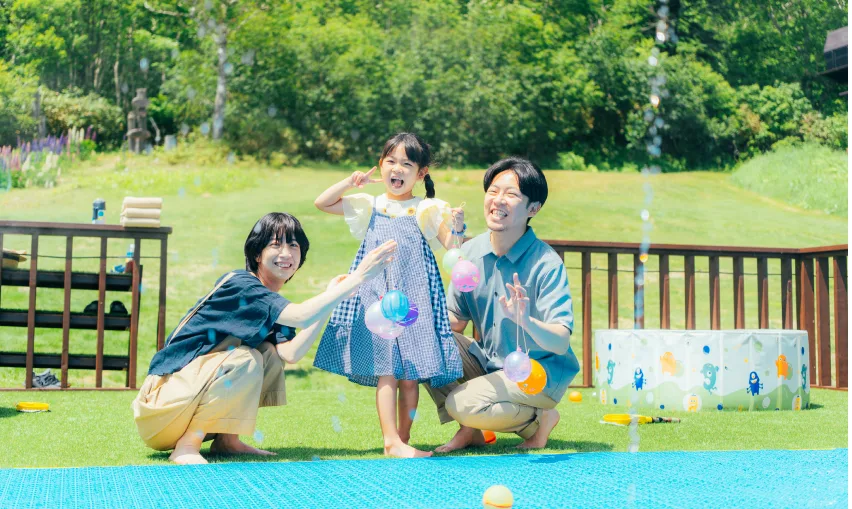 パレット噴水で水遊びをする家族