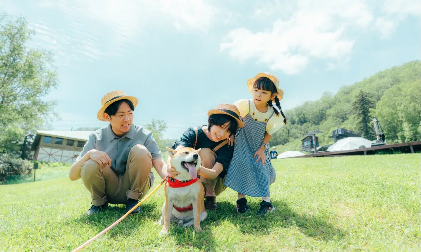 ウッドデッキで愛犬と一緒に過ごす家族