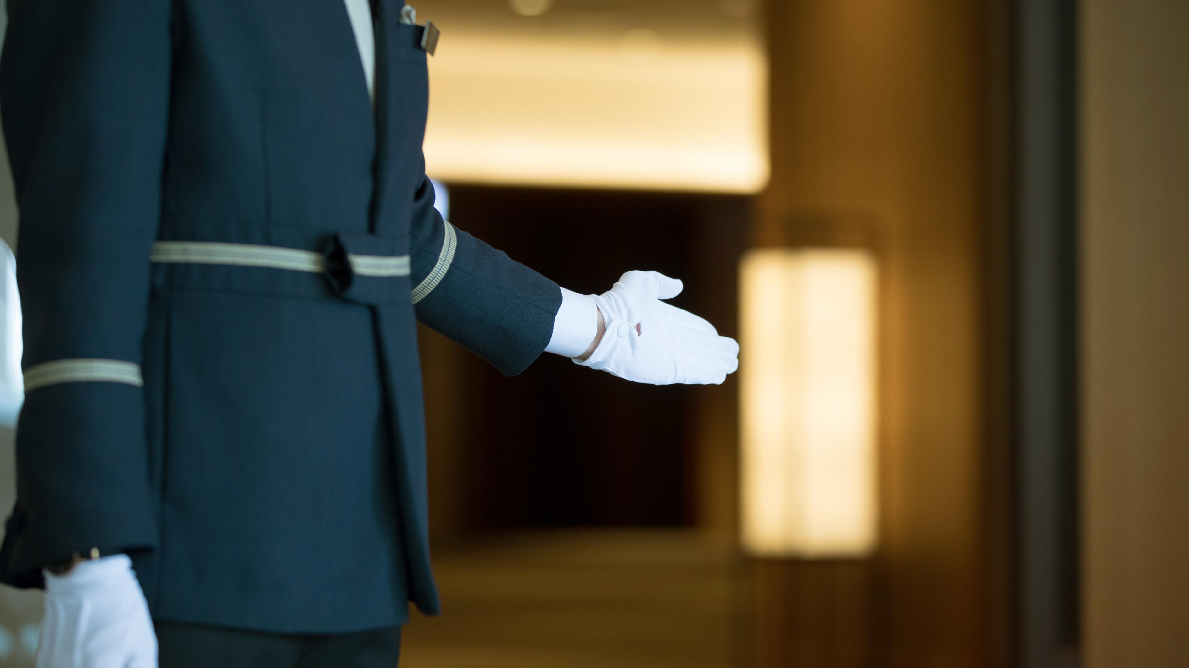 ホテルのドアマンが手でこちらへ、と誘う。