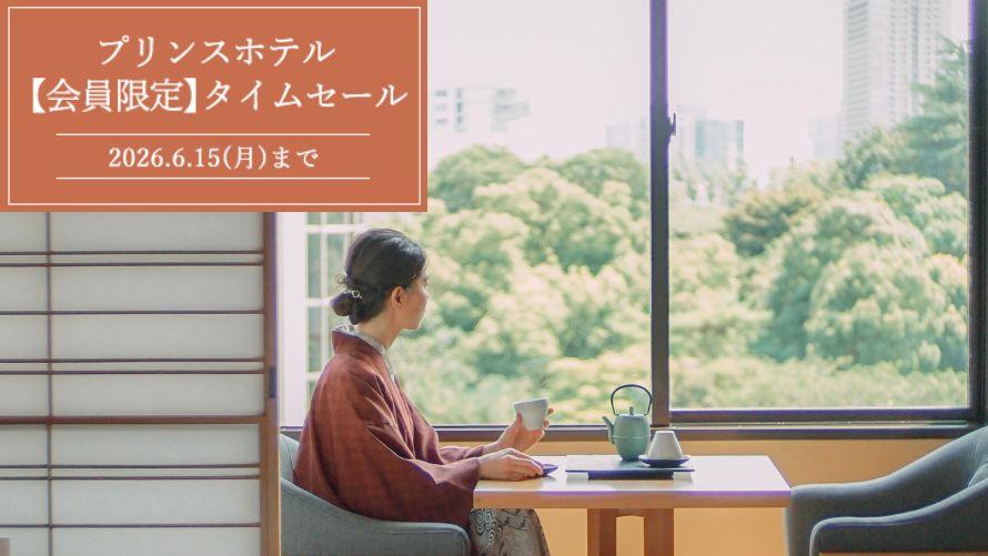 高輪 花香路客室で、お茶を飲みながら窓辺から風景を眺める浴衣姿の女性客。