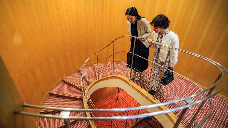 螺旋階段を上から見下ろす女性二名