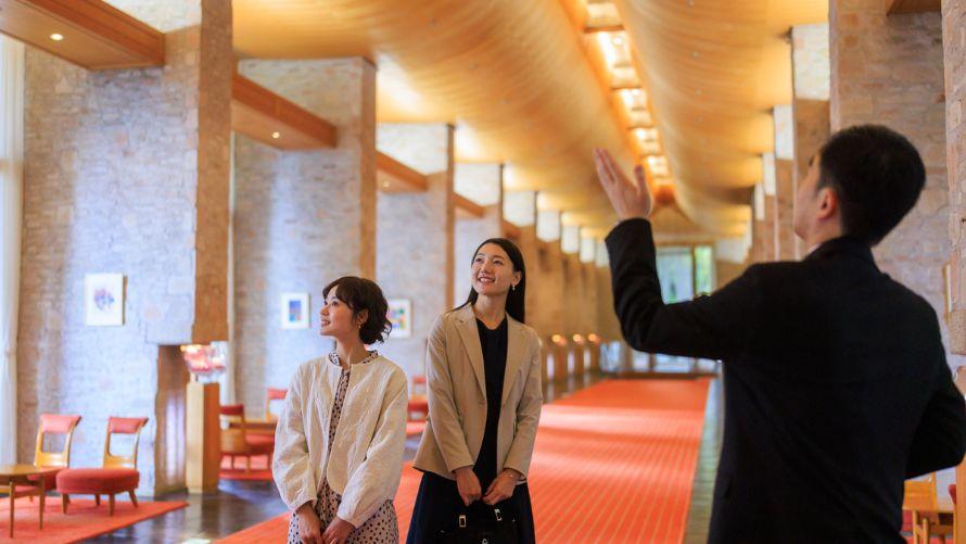 メインロビーを案内するスタッフとお客様の女性2人