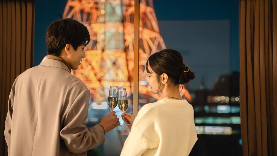 窓辺でシャンパンを手に見つめあうふたり