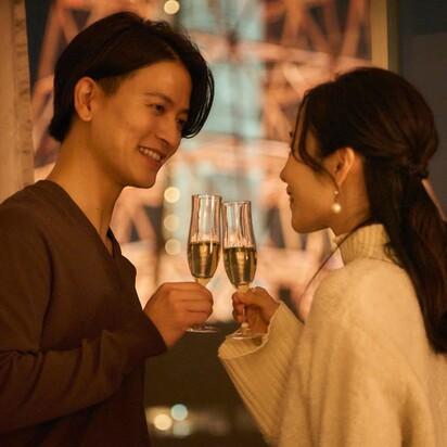 シャンパンを飲みながら向かい合うカップル